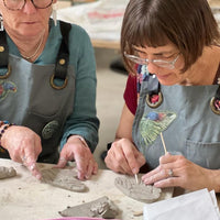 Two women working on pottery in a Jane du Rand masterclass