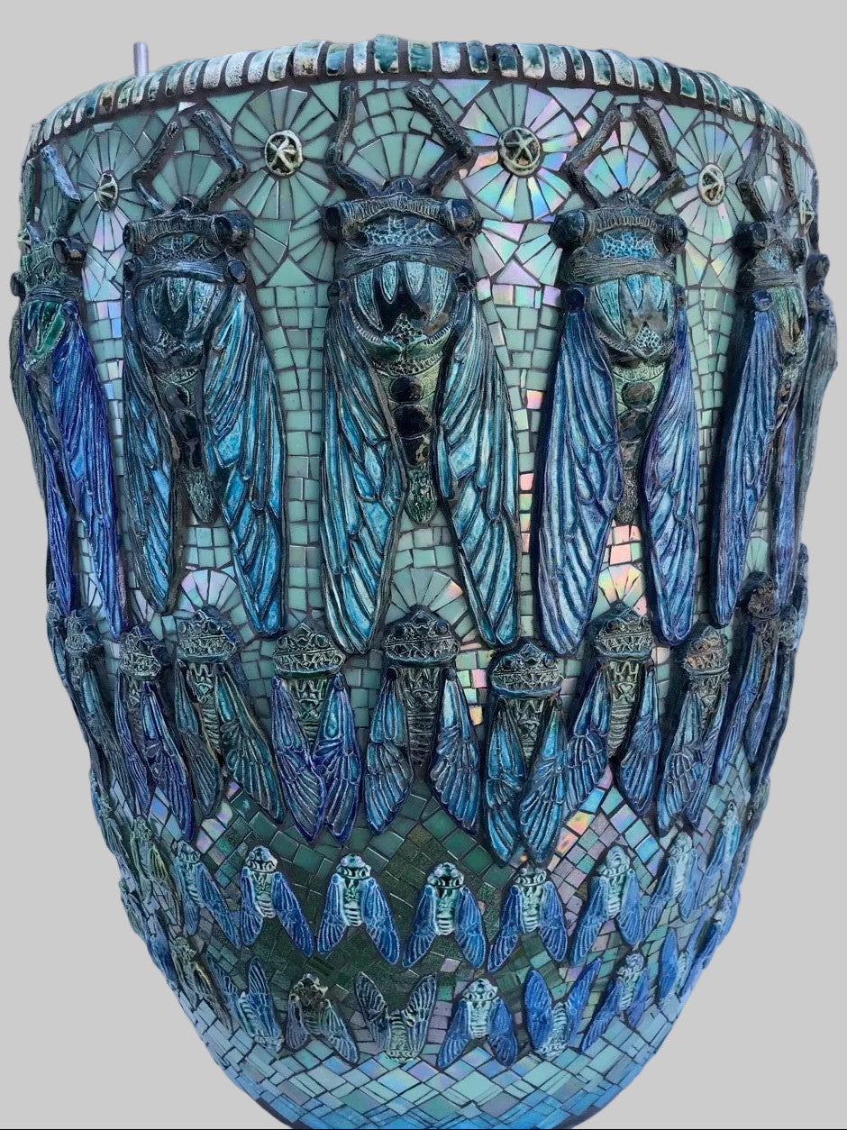 Mosaic planter with cicada design on a white surface