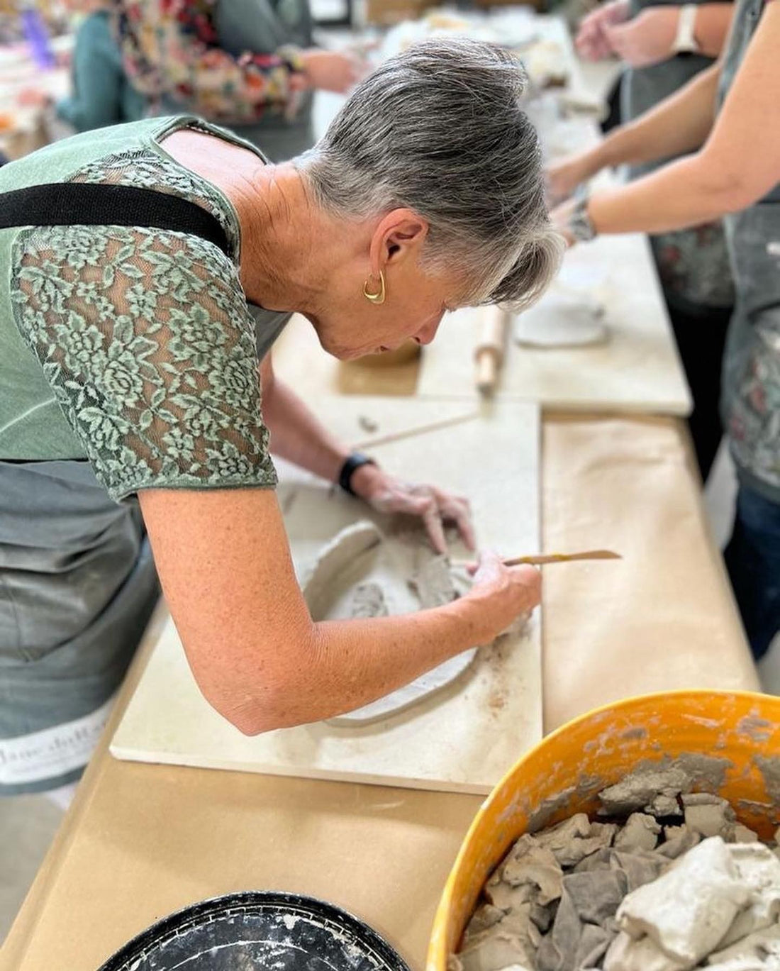 Person working with clay on a pottery wheel in a Jane du Rand masterclass